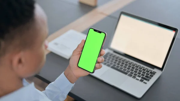 Africký muž drží Smartphone se zeleným Chroma Key Screen — Stock fotografie