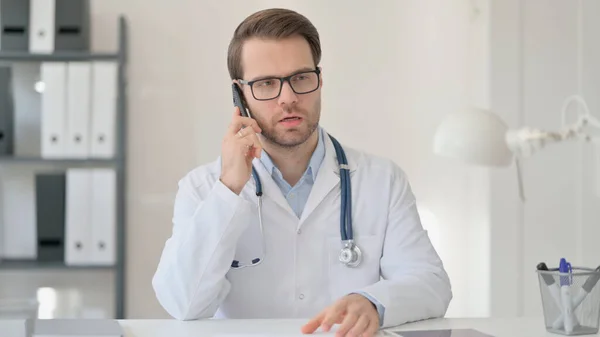 Mężczyzna lekarz mówiący na smartfon — Zdjęcie stockowe