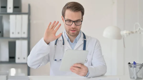 Masculino médico acenando mão para vídeo chat no tablet — Fotografia de Stock