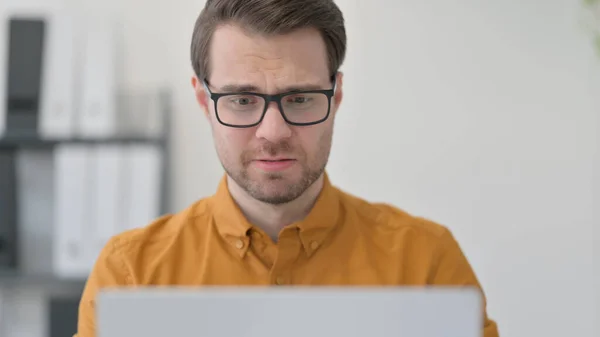 Gros plan du jeune homme en colère sur ordinateur portable au bureau, échec — Photo