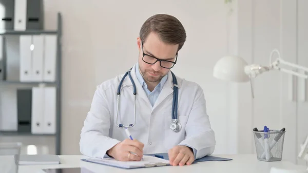 Doctor masculino leyendo archivo médico — Foto de Stock