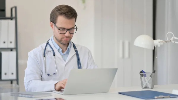 Médico masculino trabajando en el ordenador portátil en la oficina — Foto de Stock