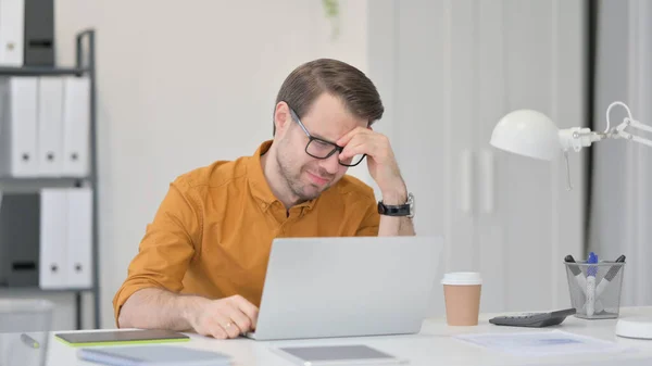 Unge man med förlust på laptop i Office — Stockfoto