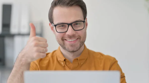 Närbild av tummen upp av ung man med bärbar dator — Stockfoto