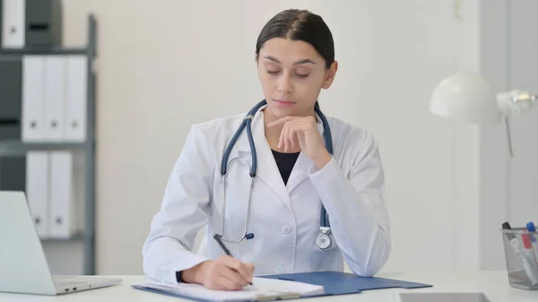 Vrouwelijke arts die op papier schrijft, medisch rapport — Stockfoto