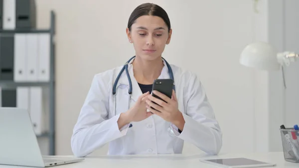 Vrouwelijke arts met behulp van Smartphone in de kliniek — Stockfoto