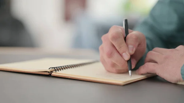 Primo piano delle Mani dell'Uomo Scrivere nel Quaderno — Foto Stock