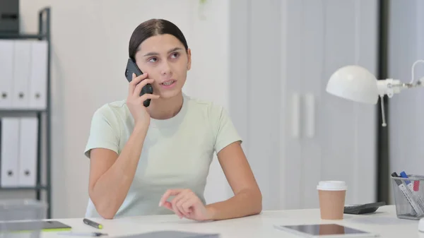 年轻的拉丁妇女在工作时通过电话交谈 — 图库照片