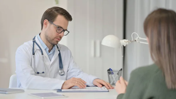 Mannelijke arts bespreken van medische rapporten met patiënt, behandeling — Stockfoto