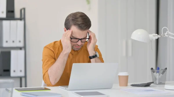 Tense tânăr om având dureri de cap la locul de muncă — Fotografie, imagine de stoc