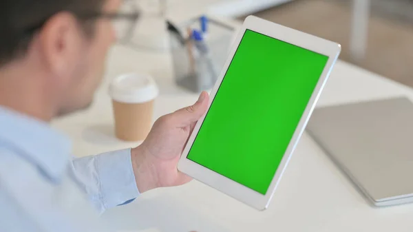 Man Χρήση Tablet με πράσινο Chroma οθόνη στο γραφείο — Φωτογραφία Αρχείου