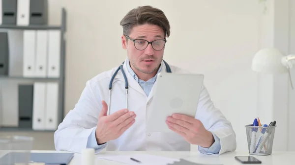 中年男性医師によるタブレット上のビデオ通話 — ストック写真