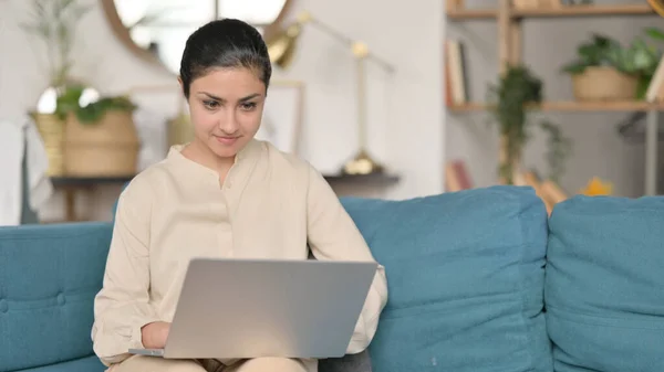 Młoda Hinduska kobieta za pomocą laptopa na kanapie — Zdjęcie stockowe