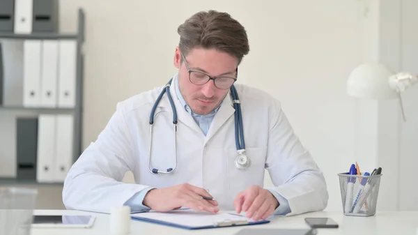 Médico leyendo informe médico en la clínica — Foto de Stock