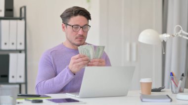 Bilgisayarlı Orta Yaşlı Adam Ofisinde Dolar Sayıyor 