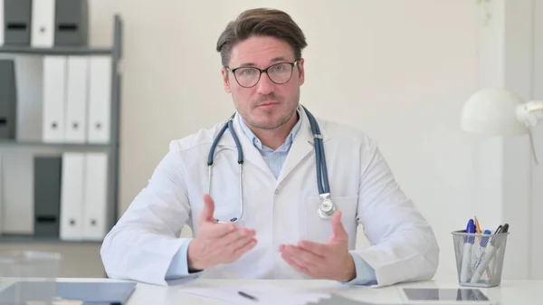 Medelålders manliga läkare talar på videosamtal — Stockfoto