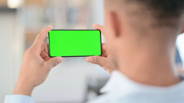 Afričan Muž Sledování Smartphone se zelenou Chroma Key Screen — Stock fotografie