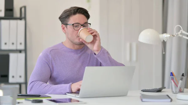 Hombre de mediana edad bebiendo café en el trabajo —  Fotos de Stock