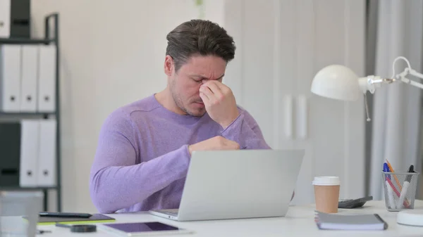 Dizüstü bilgisayarlı orta yaşlı adam ofisinde baş ağrısı çekiyor — Stok fotoğraf