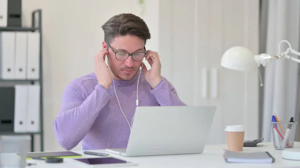Hombre de mediana edad poniendo auriculares para escuchar música —  Fotos de Stock