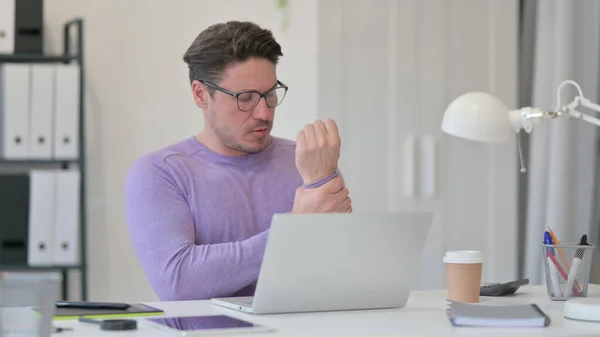 Homme du Moyen Âge avec ordinateur portable ayant la douleur au poignet dans le bureau — Photo