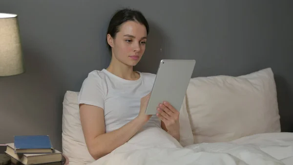 Приваблива молода жінка використовує планшет у ліжку — стокове фото