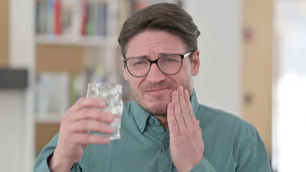 Uomo di mezza età che ha mal di denti mentre beve acqua — Foto Stock