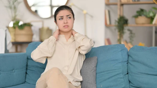 Yorgun ve boynu ağrıyan genç Hintli kadın koltukta oturuyor