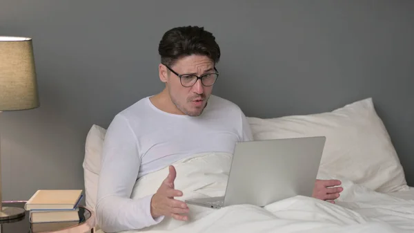 Laptop 'u olan orta yaşlı adam yatağında kayboluyor.