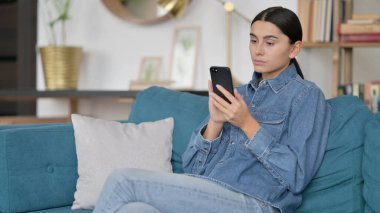 İş yerinde akıllı telefon kullanan çekici Latin Kadın 