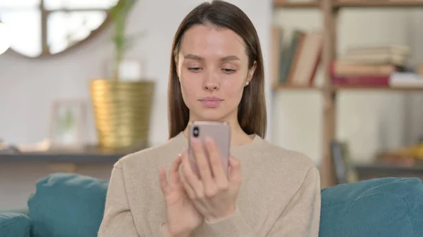 Portrait de jeune femme utilisant un smartphone à la maison — Photo