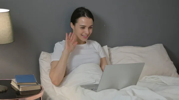 Czat wideo na laptopie przez młoda kobieta w łóżku — Zdjęcie stockowe