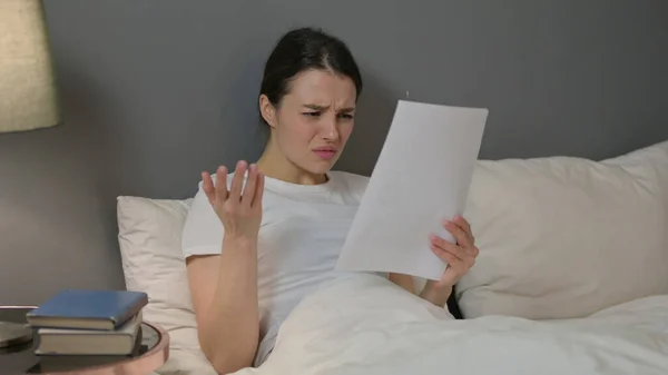 Молода жінка реагує на втрату документів у ліжку — стокове фото