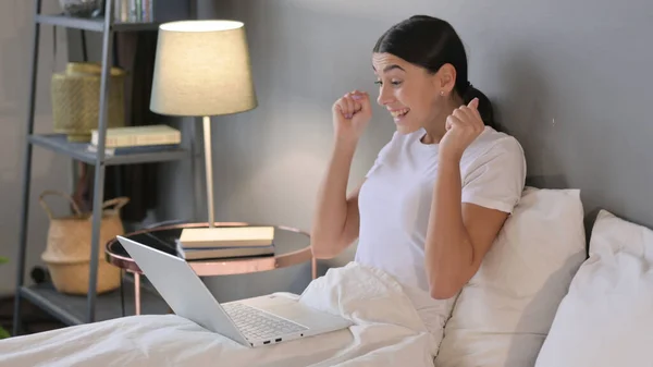 Młoda Latynoska świętuje na laptopie w łóżku — Zdjęcie stockowe