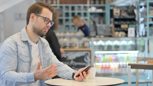 Homme créatif réagissant à la perte sur Smartphone — Photo