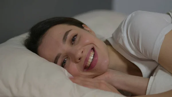 Primer plano de la joven sonriendo a la cámara en la cama — Foto de Stock