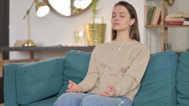 Genç Kadın Kanepede Smartphone kullanarak meditasyon yapıyor