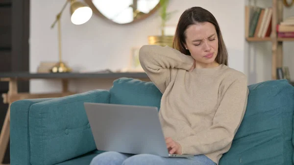 Laptop-Arbeit einer jungen Frau mit Nackenschmerzen auf Sofa — Stockfoto