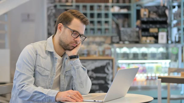 Homme créatif avec ordinateur portable faisant la sieste au café — Photo