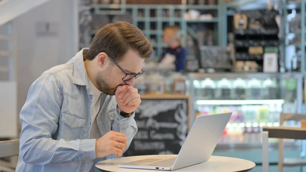 Homme créatif tousse tout en travaillant sur ordinateur portable — Photo