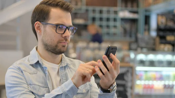 Portrait de jeune homme utilisant Smartphone dans Cafe — Photo