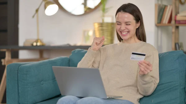 Успіх онлайн-магазинів на ноутбуці молодої жінки на дивані — стокове фото
