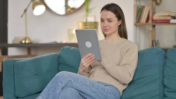 Junge Frau nutzt Tablet auf Sofa — Stockfoto