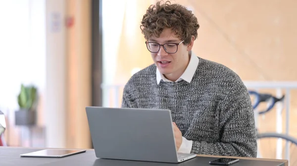 Online Video Chat στο Laptop από τον Young Man at Work — Φωτογραφία Αρχείου