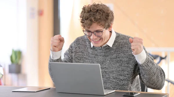 Jeune homme excité célébrant le succès sur ordinateur portable — Photo