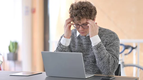 Jeune homme avec maux de tête au travail — Photo