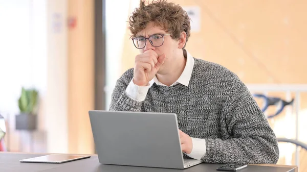 Jeune homme malade avec ordinateur portable au travail toux — Photo