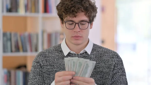 Retrato de un joven feliz contando dólares —  Fotos de Stock