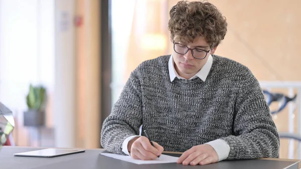 Jongeren schrijven op papier op het werk — Stockfoto