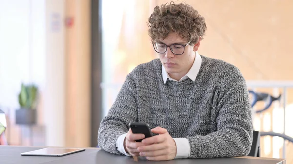 Jeune homme utilisant Smartphone au travail — Photo